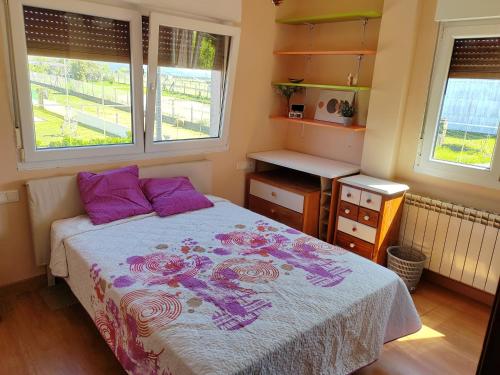 a bedroom with a bed and two windows at Casa Seán in Boiro