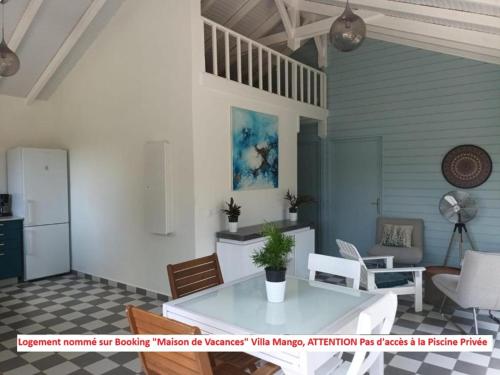 een woonkamer met een witte tafel en stoelen bij Dez'îles Guadeloupe in Sainte-Anne