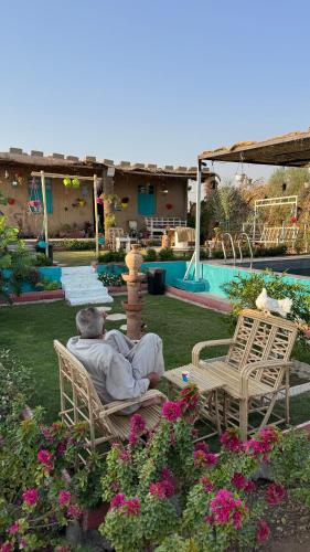 a man sitting in a chair next to a fountain at Byet ahalna in Mūsá