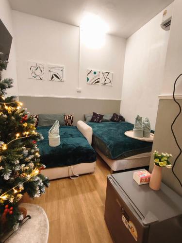a room with two beds and a christmas tree at SridaHouse#Near Central Festival Hatyai in Hat Yai