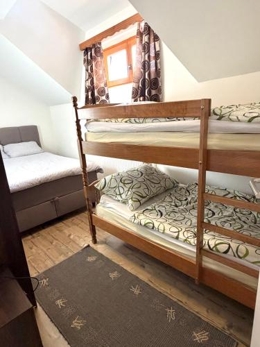 a room with two bunk beds and a couch at Gorski kotar , Kuća za odmor Kratohvil in Lukovdol