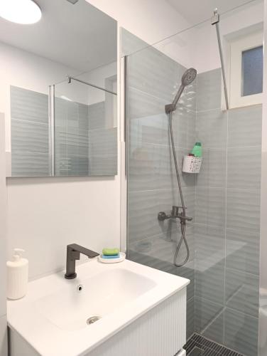 a white bathroom with a sink and a shower at Apartament Karina in Baia Mare