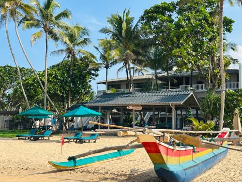 plaża z dwiema łodziami na piasku w obiekcie Suite Lanka w mieście Hikkaduwa