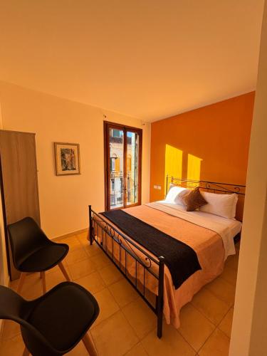 a bedroom with a bed and two chairs and a window at Hotel Canal Salieri in Venice