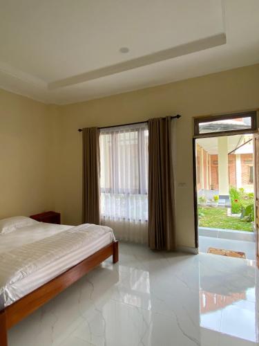 een slaapkamer met een bed en een groot raam bij SADAMA Cottage in Tuk Tuk