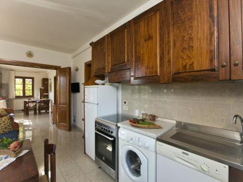 - une cuisine avec des placards en bois et un lave-vaisselle blanc dans l'établissement Huge Holiday Home in Marina di Castagneto Carducci near Sea, à Donoratico