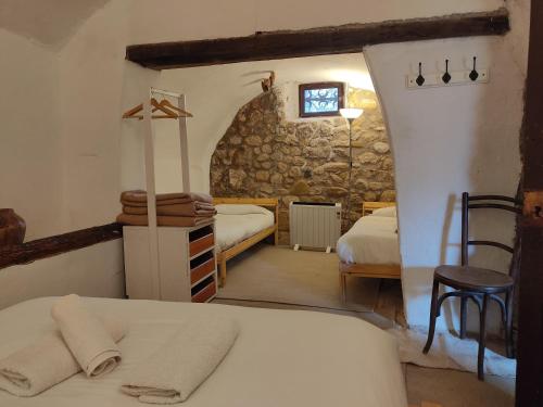 1 Schlafzimmer mit 2 Betten und einer Steinmauer in der Unterkunft Can Canals Rectoria de Dosquers in Maia de Montcal