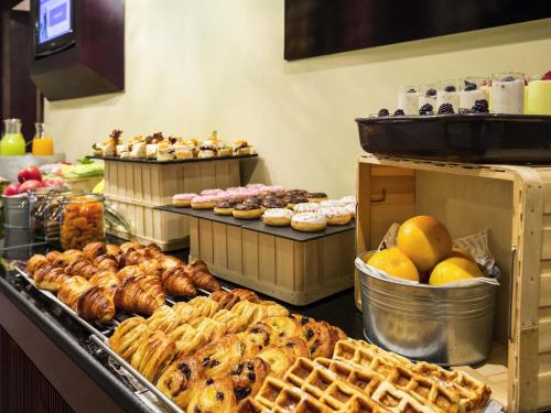 a bakery with many different types of pastries on display at Novotel Deira Creekside Dubai in Dubai