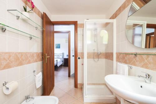 ein Badezimmer mit Waschbecken, Toilette und Spiegel in der Unterkunft Casa Vacanze l'Olivastro in Àrbatax