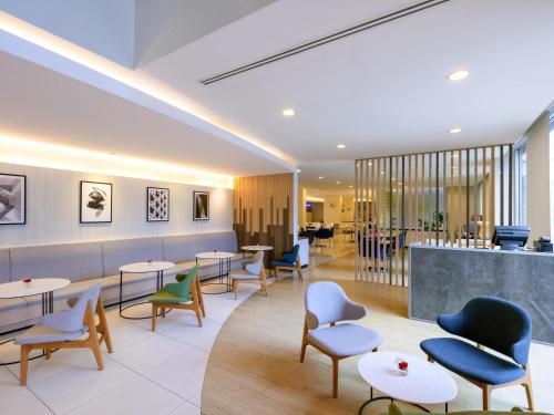 ein Restaurant mit Tischen und Stühlen und eine Bar in der Unterkunft ibis Bangkok Sathorn in Bangkok