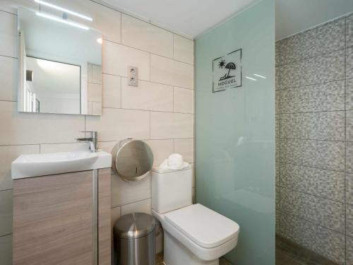 een badkamer met een toilet, een wastafel en een spiegel bij Moguel Canarian Holiday 1º in Arguineguín