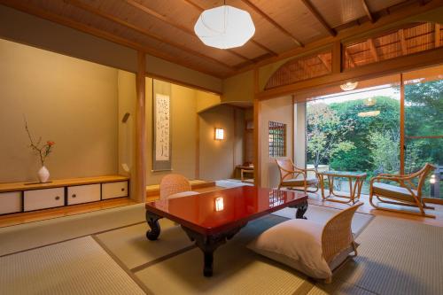 a living room with a wooden table and chairs at 御宿竹林亭 in Takeo