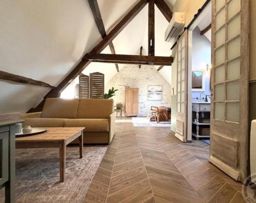 ein Wohnzimmer mit Sofa und Tisch in der Unterkunft Le petit jardin du Coudray in Étréchy