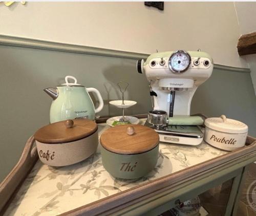 eine Theke mit einer Nähmaschine und Schüsseln darauf in der Unterkunft Le petit jardin du Coudray in Étréchy