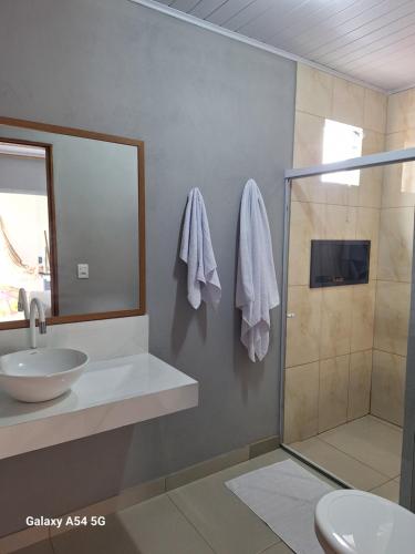 een badkamer met een wastafel en een douche bij Pousada jks in Porto Seguro