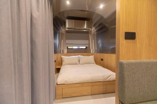 ein kleines Bett in einem kleinen Zimmer in einem Boot in der Unterkunft Nomad By Sharjah Collection in Kalbā