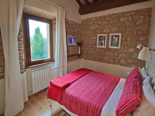 een slaapkamer met een bed met een rode deken bij Modern holiday home in Foligno - Loc with pool in Case Vecchie