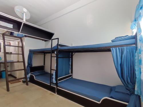une chambre avec deux lits superposés et une échelle dans l'établissement Ezekiel Transient House, à Coron