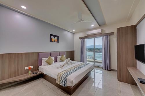 een slaapkamer met een groot bed en een televisie bij Sai Unity Boutique Stay in Garudeshwar