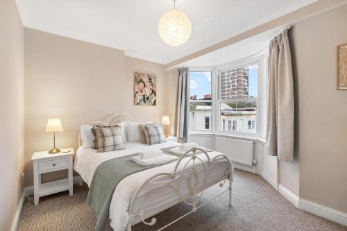 a white bedroom with a bed and a window at Spacious - Central - King Beds - Fast Wi-Fi in Brighton & Hove