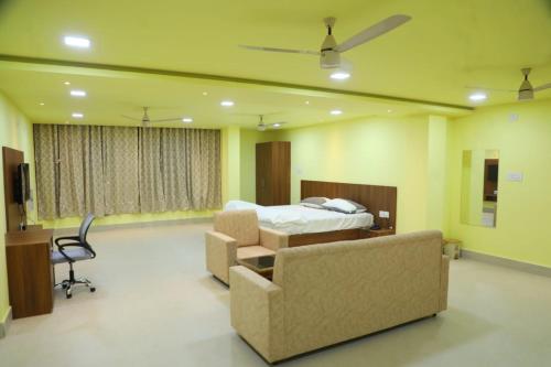 a bedroom with a bed and a couch and a chair at Manab Palace in Kendrāparha
