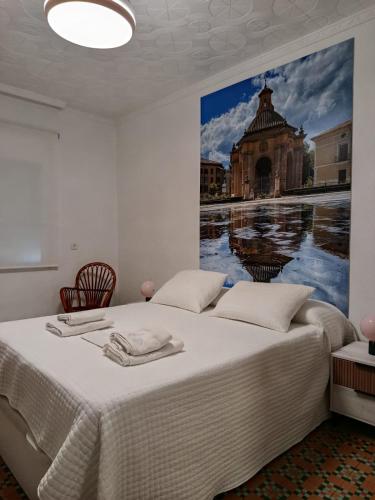 a bedroom with two beds and a painting on the wall at La Esquina Mayor in Caravaca de la Cruz