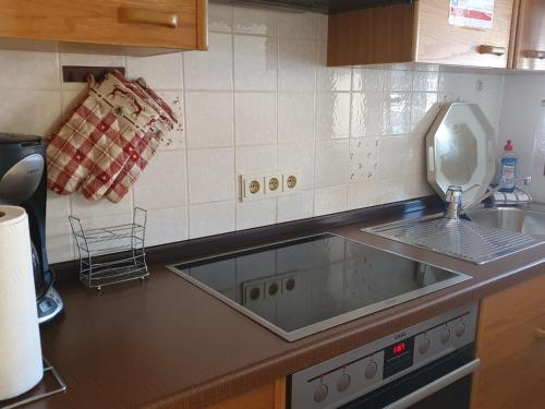 een keuken met een spoelbak en een aanrechtblad bij FeWo Steckenbergblick/Gästecard in Unterammergau