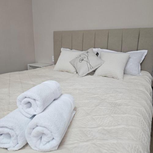 a white bed with towels on top of it at Глинки 1комн in Semey