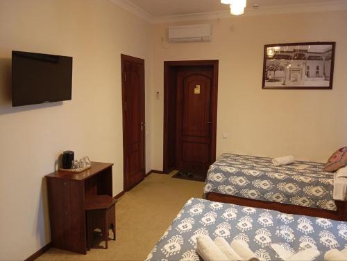 een hotelkamer met twee bedden en een televisie bij Hotel Said with a Terrace Best Location in Bukhara