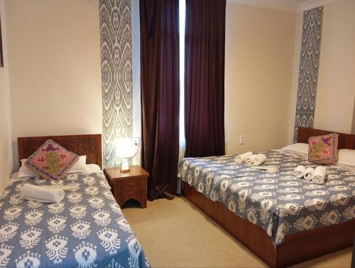 een hotelkamer met twee bedden en een raam bij Hotel Said with a Terrace Best Location in Bukhara