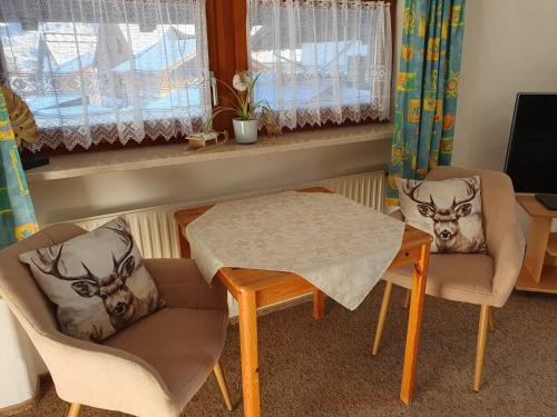 een woonkamer met een tafel en stoelen en een raam bij FeWo Steckenbergblick/Gästecard in Unterammergau