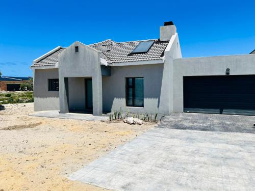 een wit huis met een grote garage bij Sakkie se Dakkie in Agulhas
