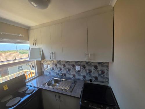 een keuken met een spoelbak en een aanrechtblad bij Chaudhray accommodation in George