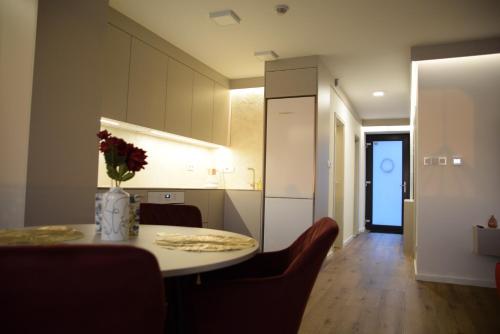 een keuken met een tafel met daarop een vaas met bloemen bij Apartmány Žermanice in Horní Soběšovice