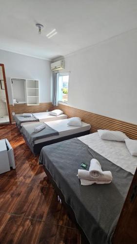 a room with four beds with towels on them at Pousada Passos de Fé in Aparecida