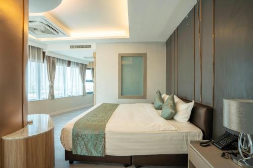 een hotelkamer met een bed en een bureau bij Enrich Grand Hotel in Bangkok