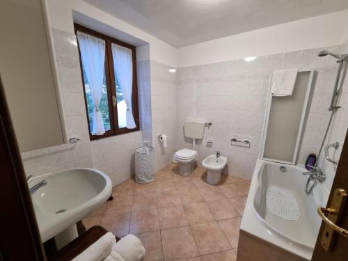 un bagno con vasca, WC e lavandino di Lago e Monti a Zone