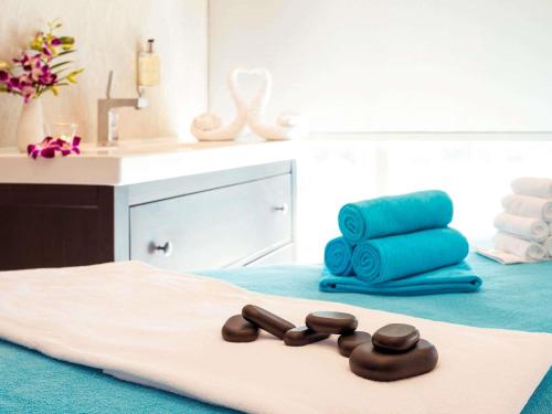 a room with a bed with a sink and a pile of towels at Ibis Abu Dhabi Gate in Abu Dhabi