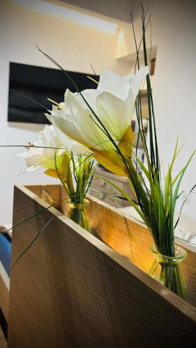 een witte bloem in twee vazen op een toonbank bij CitiMarina56 in Brodnica