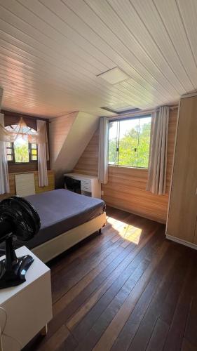 a bedroom with a bed and a large window at Recanto da Natureza in Matinhos