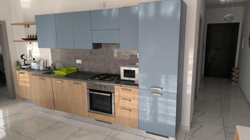 een keuken met houten kasten en een roestvrijstalen koelkast bij Large Terrace with Valletta Views in Il-Gżira