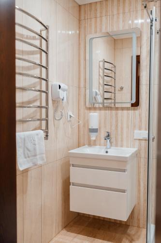 a bathroom with a sink and a mirror at Soprano Inn Hotel in Lviv