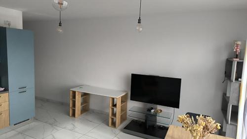 een woonkamer met een tafel en een tv aan de muur bij Large Terrace with Valletta Views in Il-Gżira