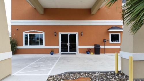 a front door of a building with a driveway at Studio 6-Beeville, TX in Beeville