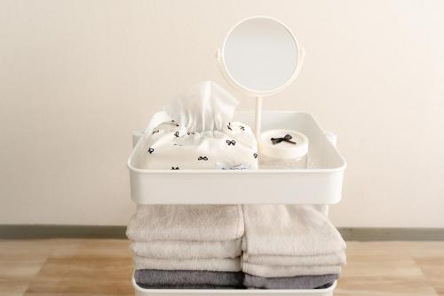 a white bath tub filled with towels and a mirror at Hani Stay Fukuoka Kaizuka-Timesカーシェアあり- in Fukuoka