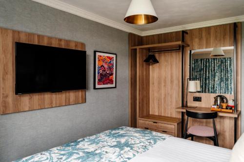 a bedroom with a bed and a flat screen tv at Craig Manor in Bowness-on-Windermere