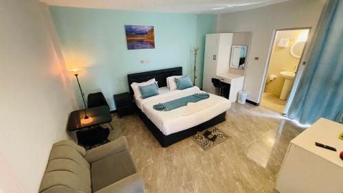 a bedroom with a king sized bed and a couch at Solkeb Hotel in Jijiga