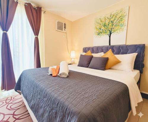 ein Schlafzimmer mit einem großen Bett mit einem großen Fenster in der Unterkunft AdahkuMaya Luxury Suites in Manila