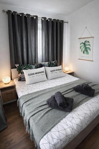 a bedroom with a large bed with black curtains at Charming City Apartment SIYANA - Self Check-in in Panagyurishte