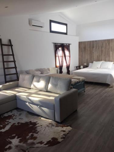 a living room with a couch and a bed at HOTEL RESTAURANT TURÓ de la TORRE in Manresa